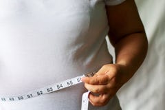 Το παχύ άτομο ελέγχει το λίπος σας με μια μετρώντας ταινία για το υπόβαθρο λευκού ή παχυσαρκίας στοκ φωτογραφίες Το παχύ άτομο ελέγχει το λίπος σας με μια μετρώντας ταινία για το υπόβαθρο λευκού ή παχυσαρκίας στοκ φωτογραφίες