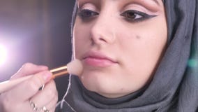 Το πορτρέτο θηλυκό να κάνει χεριών ετοιμάζει και της τοποθέτησης του highlighter για τη νέα μουσουλμανική γυναίκα στο hijab στα φ απόθεμα βίντεο Το πορτρέτο θηλυκό να κάνει χεριών ετοιμάζει και της τοποθέτησης του highlighter για τη νέα μουσουλμανική γυναίκα στο hijab στα φ απόθεμα βίντεο