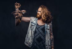 Το πορτρέτο του α το redhead αρσενικό hipster με τη μακριά άφθονη τρίχα και η πλήρης γενειάδα έντυσε σε μια μπλούζα και το σακάκι στοκ φωτογραφίες Το πορτρέτο του α το redhead αρσενικό hipster με τη μακριά άφθονη τρίχα και η πλήρης γενειάδα έντυσε σε μια μπλούζα και το σακάκι στοκ φωτογραφίες