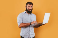 Το πορτρέτο του όμορφου χαμογελώντας ατόμου που απομονώθηκε στην κίτρινη τοποθέτηση υποβάθρου στούντιο στη κάμερα και την παραγωγ Στοκ εικόνα με δικαίωμα ελεύθερης χρήσης Το πορτρέτο του όμορφου χαμογελώντας ατόμου που απομονώθηκε στην κίτρινη τοποθέτηση υποβάθρου στούντιο στη κάμερα και την παραγωγ Στοκ εικόνα με δικαίωμα ελεύθερης χρήσης