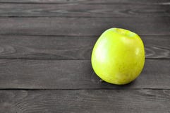 Το πράσινο μήλο βρίσκεται σε έναν ξύλινο πίνακα στοκ φωτογραφία Το πράσινο μήλο βρίσκεται σε έναν ξύλινο πίνακα στοκ φωτογραφία