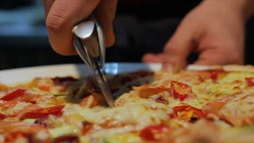 Το πρόσωπο κινηματογραφήσεων σε πρώτο πλάνο κόβει την ιταλική πίτσα στα κομμάτια στο πιάτο απόθεμα βίντεο Το πρόσωπο κινηματογραφήσεων σε πρώτο πλάνο κόβει την ιταλική πίτσα στα κομμάτια στο πιάτο απόθεμα βίντεο