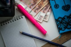 Το σπίτι στον πίνακα είναι ένα σημειωματάριο, χρήματα, ένα μολύβι, ένας ρόδινος δείκτης, ένας κυβερνήτης, μάνδρες στοκ εικόνα Το σπίτι στον πίνακα είναι ένα σημειωματάριο, χρήματα, ένα μολύβι, ένας ρόδινος δείκτης, ένας κυβερνήτης, μάνδρες στοκ εικόνα