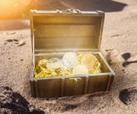 Το στήθος θησαυρών που γέμισαν με τα bitcoins που περιβλήθηκαν από τη χρυσή πυράκτωση μερικώς στην άμμο Στοκ Φωτογραφία Το στήθος θησαυρών που γέμισαν με τα bitcoins που περιβλήθηκαν από τη χρυσή πυράκτωση μερικώς στην άμμο Στοκ Φωτογραφία