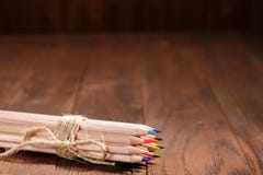 Το σύνολο αιχμηρών ζωηρόχρωμων μολυβιών έδεσε με το σχοινί μαλλιού σε έναν ξύλινο κενό πίνακα στοκ εικόνες με δικαίωμα ελεύθερης χρήσης Το σύνολο αιχμηρών ζωηρόχρωμων μολυβιών έδεσε με το σχοινί μαλλιού σε έναν ξύλινο κενό πίνακα στοκ εικόνες με δικαίωμα ελεύθερης χρήσης