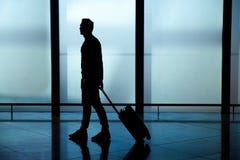 Το σύρσιμο επιχειρηματιών συνεχίζει τη βαλίτσα αποσκευών στο διάδρομο αερολιμένων περπατώντας στις πύλες αναχώρησης στοκ εικόνες με δικαίωμα ελεύθερης χρήσης Το σύρσιμο επιχειρηματιών συνεχίζει τη βαλίτσα αποσκευών στο διάδρομο αερολιμένων περπατώντας στις πύλες αναχώρησης στοκ εικόνες με δικαίωμα ελεύθερης χρήσης