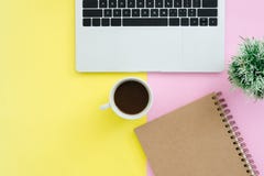 Το τοπ γραφείο γραφείων άποψης με το lap-top, τα σημειωματάρια και το φλυτζάνι καφέ στην κρητιδογραφία χρωματίζουν το υπόβαθρο στοκ φωτογραφία με δικαίωμα ελεύθερης χρήσης Το τοπ γραφείο γραφείων άποψης με το lap-top, τα σημειωματάρια και το φλυτζάνι καφέ στην κρητιδογραφία χρωματίζουν το υπόβαθρο στοκ φωτογραφία με δικαίωμα ελεύθερης χρήσης