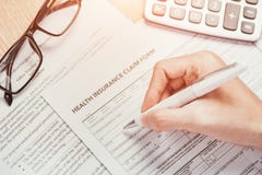 Το χέρι γράφει τη προσωπική πληροφορία στη μορφή αξίωσης ασφάλειας υγείας στοκ εικόνες Το χέρι γράφει τη προσωπική πληροφορία στη μορφή αξίωσης ασφάλειας υγείας στοκ εικόνες