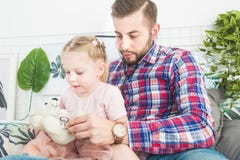 Το χαριτωμένο μικρό κορίτσι και ο πατέρας της παίζουν το γιατρό στο σπίτι στοκ εικόνες Το χαριτωμένο μικρό κορίτσι και ο πατέρας της παίζουν το γιατρό στο σπίτι στοκ εικόνες