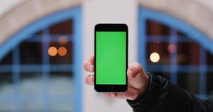 Το χιόνι πέφτει πέρα από ένα smartphone εκμετάλλευσης χεριών ατόμων ` s με την πράσινη οθόνη στο βραχίονά του Το χιόνι πέφτει πέρα από ένα smartphone εκμετάλλευσης χεριών ατόμων ` s με την πράσινη οθόνη στο βραχίονά του