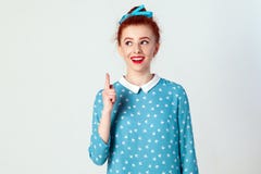 Το όμορφο redhead κορίτσι πήρε την ιδέα και αύξησε το δάχτυλό της επάνω στοκ εικόνα Το όμορφο redhead κορίτσι πήρε την ιδέα και αύξησε το δάχτυλό της επάνω στοκ εικόνα