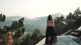 Το όμορφο νέο πρότυπο γυναικών με μακρυμάλλη σε ένα μαύρο χνουδωτό κομψό μακρύ φόρεμα περπατά κατά μήκος του μπαλκονιού απόθεμα βίντεο Το όμορφο νέο πρότυπο γυναικών με μακρυμάλλη σε ένα μαύρο χνουδωτό κομψό μακρύ φόρεμα περπατά κατά μήκος του μπαλκονιού απόθεμα βίντεο