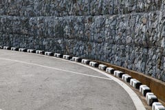 Τοίχος Gabion κοντά στο συγκεκριμένο δρόμο στοκ φωτογραφία με δικαίωμα ελεύθερης χρήσης Τοίχος Gabion κοντά στο συγκεκριμένο δρόμο στοκ φωτογραφία με δικαίωμα ελεύθερης χρήσης