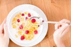Τοπ άποψη της γυναίκας που τρώει το muesli με τη φράουλα και το γάλα στοκ εικόνες Τοπ άποψη της γυναίκας που τρώει το muesli με τη φράουλα και το γάλα στοκ εικόνες