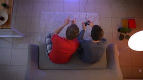 Τοπ πυροβολισμός δύο νέων τύπων videogame παιχνιδιού πιτζαμάτων και επικοινωνία με τις ενεργές χειρονομίες στο καθιστικό απόθεμα βίντεο Τοπ πυροβολισμός δύο νέων τύπων videogame παιχνιδιού πιτζαμάτων και επικοινωνία με τις ενεργές χειρονομίες στο καθιστικό απόθεμα βίντεο