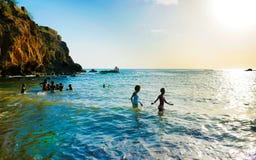 Τοπίο, Teens και παιδιά Πράσινου Ακρωτηρίου ωκεάνιο που παίζουν στο νερό, μαύρη ηφαιστειακή παραλία Στοκ Εικόνα Τοπίο, Teens και παιδιά Πράσινου Ακρωτηρίου ωκεάνιο που παίζουν στο νερό, μαύρη ηφαιστειακή παραλία Στοκ Εικόνα