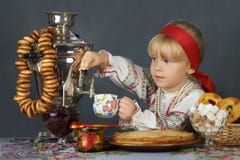 Τσάι κατανάλωσης μικρών κοριτσιών παραδοσιακούς ρωσικούς στο sarafan και το πουκάμισο στοκ εικόνα με δικαίωμα ελεύθερης χρήσης Τσάι κατανάλωσης μικρών κοριτσιών παραδοσιακούς ρωσικούς στο sarafan και το πουκάμισο στοκ εικόνα με δικαίωμα ελεύθερης χρήσης