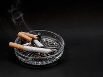 Τσιγάρο ashtray σε ένα μαύρο υπόβαθρο καπνός στοκ φωτογραφία με δικαίωμα ελεύθερης χρήσης Τσιγάρο ashtray σε ένα μαύρο υπόβαθρο καπνός στοκ φωτογραφία με δικαίωμα ελεύθερης χρήσης