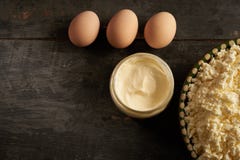 Τυρί εξοχικών σπιτιών, ξινή κρέμα και τρία αυγά στον ξύλινο πίνακα στοκ φωτογραφίες με δικαίωμα ελεύθερης χρήσης Τυρί εξοχικών σπιτιών, ξινή κρέμα και τρία αυγά στον ξύλινο πίνακα στοκ φωτογραφίες με δικαίωμα ελεύθερης χρήσης