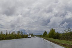 Υγρός αγροτικός δρόμος, που πηγαίνει στην απόσταση Γύρω από τα πυκνά αλσύλλια των δέντρων και των θάμνων E στοκ φωτογραφία με δικαίωμα ελεύθερης χρήσης Υγρός αγροτικός δρόμος, που πηγαίνει στην απόσταση Γύρω από τα πυκνά αλσύλλια των δέντρων και των θάμνων E στοκ φωτογραφία με δικαίωμα ελεύθερης χρήσης