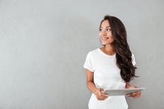 Υπολογιστής ταμπλετών εκμετάλλευσης γυναικών αρκετά χαμόγελου ασιατικός Στοκ Εικόνες Υπολογιστής ταμπλετών εκμετάλλευσης γυναικών αρκετά χαμόγελου ασιατικός Στοκ Εικόνες