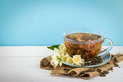 Φλυτζάνι του πράσινου τσαγιού με jasmine τα λουλούδια στο ξύλινο υπόβαθρο στοκ εικόνες Φλυτζάνι του πράσινου τσαγιού με jasmine τα λουλούδια στο ξύλινο υπόβαθρο στοκ εικόνες