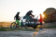 Φίλοι που βγάζουν τα ποδήλατα MTB από το πλαϊνό φορτηγό επαναλείψεων στα βουνά στο ηλιοβασίλεμα Έννοια περιπέτειας και ταξιδιού στοκ φωτογραφία με δικαίωμα ελεύθερης χρήσης Φίλοι που βγάζουν τα ποδήλατα MTB από το πλαϊνό φορτηγό επαναλείψεων στα βουνά στο ηλιοβασίλεμα Έννοια περιπέτειας και ταξιδιού στοκ φωτογραφία με δικαίωμα ελεύθερης χρήσης
