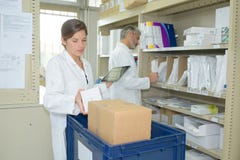 Φαρμακοποιός που κρατά την ψηφιακή ταμπλέτα στην αποθήκη φαρμακείων στοκ φωτογραφίες Φαρμακοποιός που κρατά την ψηφιακή ταμπλέτα στην αποθήκη φαρμακείων στοκ φωτογραφίες