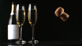 Φελλός CHAMPAGNE που πέφτει μπροστά από δύο φλάουτα και μπουκάλι γυαλιού Φελλός CHAMPAGNE που πέφτει μπροστά από δύο φλάουτα και μπουκάλι γυαλιού