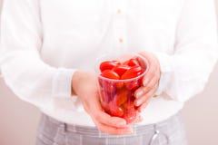 Φλυτζάνι εκμετάλλευσης επιχειρηματιών με τις φρέσκες μικρές ντομάτες στοκ φωτογραφία με δικαίωμα ελεύθερης χρήσης Φλυτζάνι εκμετάλλευσης επιχειρηματιών με τις φρέσκες μικρές ντομάτες στοκ φωτογραφία με δικαίωμα ελεύθερης χρήσης