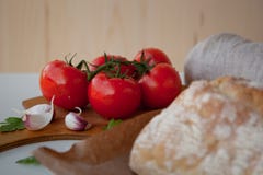 Φρέσκες ντομάτες στο ξύλινο γραφείο με το σκόρδο στοκ φωτογραφίες Φρέσκες ντομάτες στο ξύλινο γραφείο με το σκόρδο στοκ φωτογραφίες