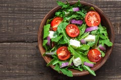 Φρέσκια σαλάτα mixd με το rucola, το κεράσι ντοματών, το τυρί φέτας και το κόκκινο κρεμμύδι σε ένα κύπελλο στον αγροτικό ξύλινο π στοκ φωτογραφίες Φρέσκια σαλάτα mixd με το rucola, το κεράσι ντοματών, το τυρί φέτας και το κόκκινο κρεμμύδι σε ένα κύπελλο στον αγροτικό ξύλινο π στοκ φωτογραφίες