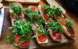Φρέσκο υποβρύχιο σάντουιτς baguette με το ζαμπόν, το τυρί, τις ντομάτες και τον άγριο πύραυλο r στοκ εικόνα με δικαίωμα ελεύθερης χρήσης Φρέσκο υποβρύχιο σάντουιτς baguette με το ζαμπόν, το τυρί, τις ντομάτες και τον άγριο πύραυλο r στοκ εικόνα με δικαίωμα ελεύθερης χρήσης