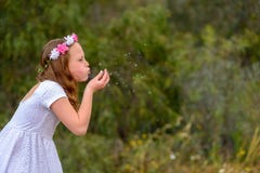 Φυσώντας πικραλίδα κοριτσιών εφήβων στοκ εικόνα Φυσώντας πικραλίδα κοριτσιών εφήβων στοκ εικόνα