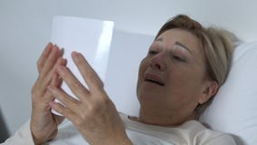 Φωνάζοντας ανώτερη γυναίκα που βρίσκεται στο κρεβάτι και που εξετάζει τη φωτογραφία, που θυμάται το σύζυγο φιλμ μικρού μήκους Φωνάζοντας ανώτερη γυναίκα που βρίσκεται στο κρεβάτι και που εξετάζει τη φωτογραφία, που θυμάται το σύζυγο φιλμ μικρού μήκους
