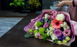 Φωτεινή ανθοδέσμη των φρέσκων λουλουδιών σε έναν καφετή ξύλινο πίνακα στοκ εικόνες Φωτεινή ανθοδέσμη των φρέσκων λουλουδιών σε έναν καφετή ξύλινο πίνακα στοκ εικόνες