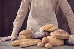Χέρι και διαφορετικοί τύποι ψωμιών στο ξύλινο υπόβαθρο στοκ φωτογραφία Χέρι και διαφορετικοί τύποι ψωμιών στο ξύλινο υπόβαθρο στοκ φωτογραφία