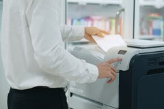 Χέρι που βάζει ένα έγγραφο εγγράφων στον ανιχνευτή εκτυπωτών ή τη μηχανή αντιγράφων λέιζερ στην αρχή στοκ φωτογραφία Χέρι που βάζει ένα έγγραφο εγγράφων στον ανιχνευτή εκτυπωτών ή τη μηχανή αντιγράφων λέιζερ στην αρχή στοκ φωτογραφία