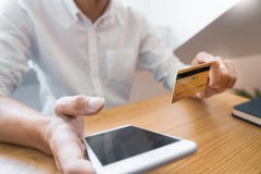 Χέρι του ατόμου στο περιστασιακό πουκάμισο που πληρώνει με την πιστωτική κάρτα και που χρησιμοποιεί το έξυπνο τηλέφωνο για on-lin στοκ εικόνες με δικαίωμα ελεύθερης χρήσης Χέρι του ατόμου στο περιστασιακό πουκάμισο που πληρώνει με την πιστωτική κάρτα και που χρησιμοποιεί το έξυπνο τηλέφωνο για on-lin στοκ εικόνες με δικαίωμα ελεύθερης χρήσης