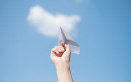Χέρια ατόμων που κρατούν έναν πύραυλο της Λευκής Βίβλου με ένα φωτεινό μπλε υπόβαθρο στοκ φωτογραφίες Χέρια ατόμων που κρατούν έναν πύραυλο της Λευκής Βίβλου με ένα φωτεινό μπλε υπόβαθρο στοκ φωτογραφίες