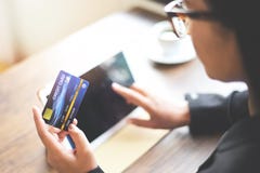 Χέρια γυναικών που κρατούν την πιστωτική κάρτα και που χρησιμοποιούν την ταμπλέτα για on-line να ψωνίσει σε ένα υπόβαθρο φλυτζανι στοκ φωτογραφία με δικαίωμα ελεύθερης χρήσης Χέρια γυναικών που κρατούν την πιστωτική κάρτα και που χρησιμοποιούν την ταμπλέτα για on-line να ψωνίσει σε ένα υπόβαθρο φλυτζανι στοκ φωτογραφία με δικαίωμα ελεύθερης χρήσης