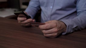 Χέρια ενός επιχειρηματία που κρατά το κινητό τηλέφωνο και την πιστωτική κάρτα Χρησιμοποιεί την πιστωτική κάρτα του για να πληρώσε απόθεμα βίντεο Χέρια ενός επιχειρηματία που κρατά το κινητό τηλέφωνο και την πιστωτική κάρτα Χρησιμοποιεί την πιστωτική κάρτα του για να πληρώσε απόθεμα βίντεο