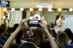 Χέρια ενός κοριτσιού με ένα τηλέφωνο στο θολωμένο υπόβαθρο μιας κύριας κατηγορίας στοκ εικόνες Χέρια ενός κοριτσιού με ένα τηλέφωνο στο θολωμένο υπόβαθρο μιας κύριας κατηγορίας στοκ εικόνες