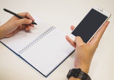 Χέρια στη μάνδρα και τη χρησιμοποίηση του smartphone συγχρόνως στοκ εικόνες Χέρια στη μάνδρα και τη χρησιμοποίηση του smartphone συγχρόνως στοκ εικόνες