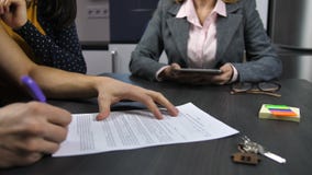 Χέρια συζύγων ` s που υπογράφουν τη σύμβαση υποθηκών Χέρια συζύγων ` s που υπογράφουν τη σύμβαση υποθηκών