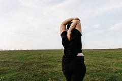 Χέρια τεντώματος γυναικών συν-μεγέθους που χαλαρώνουν υπαίθρια στοκ φωτογραφία Χέρια τεντώματος γυναικών συν-μεγέθους που χαλαρώνουν υπαίθρια στοκ φωτογραφία