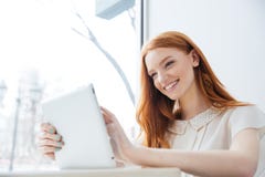 Χαμογελώντας γοητευτική redhead νέα γυναίκα με την ταμπλέτα στον καφέ στοκ φωτογραφία με δικαίωμα ελεύθερης χρήσης Χαμογελώντας γοητευτική redhead νέα γυναίκα με την ταμπλέτα στον καφέ στοκ φωτογραφία με δικαίωμα ελεύθερης χρήσης