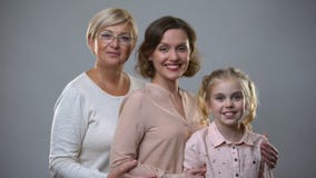 Χαμογελώντας multigeneration θηλυκά στο γκρίζο υπόβαθρο, οικογενειακή σύνδεσ απόθεμα βίντεο Χαμογελώντας multigeneration θηλυκά στο γκρίζο υπόβαθρο, οικογενειακή σύνδεσ απόθεμα βίντεο