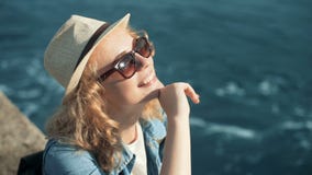 Χαμογελώντας γυναίκα που απολαμβάνει το θερινό ήλιο σε ένα άσπρο καπέλο ήλιων στην παραλία Χαμογελώντας γυναίκα που απολαμβάνει το θερινό ήλιο σε ένα άσπρο καπέλο ήλιων στην παραλία