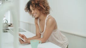 Χαμογελώντας ευτυχής αμερικανική γυναίκα afro που χρησιμοποιεί την ταμπλέτα PC στο σπίτι απόθεμα βίντεο Χαμογελώντας ευτυχής αμερικανική γυναίκα afro που χρησιμοποιεί την ταμπλέτα PC στο σπίτι απόθεμα βίντεο